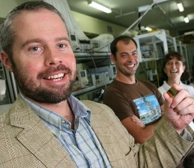 Professor Ben Eggleton (foreground) holding a photonic chip with (from left) student Neil Baker and researcher Snjezana Tomljenovic-Hanic 